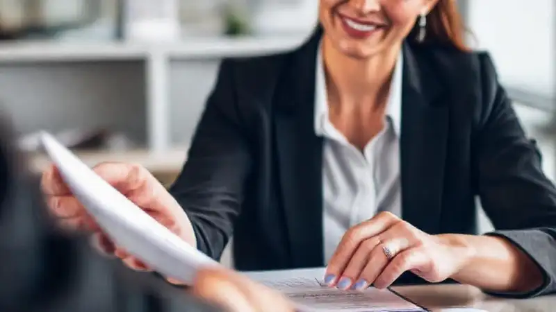 Una mujer de negocios firma un acuerdo